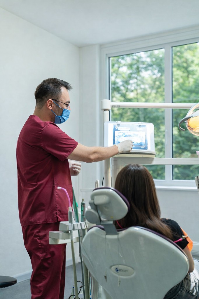 Medicul explicând tratamentul unui pacient la scaun.